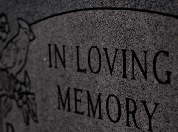 a close up of a grave with the words In Loving Memory inscribed